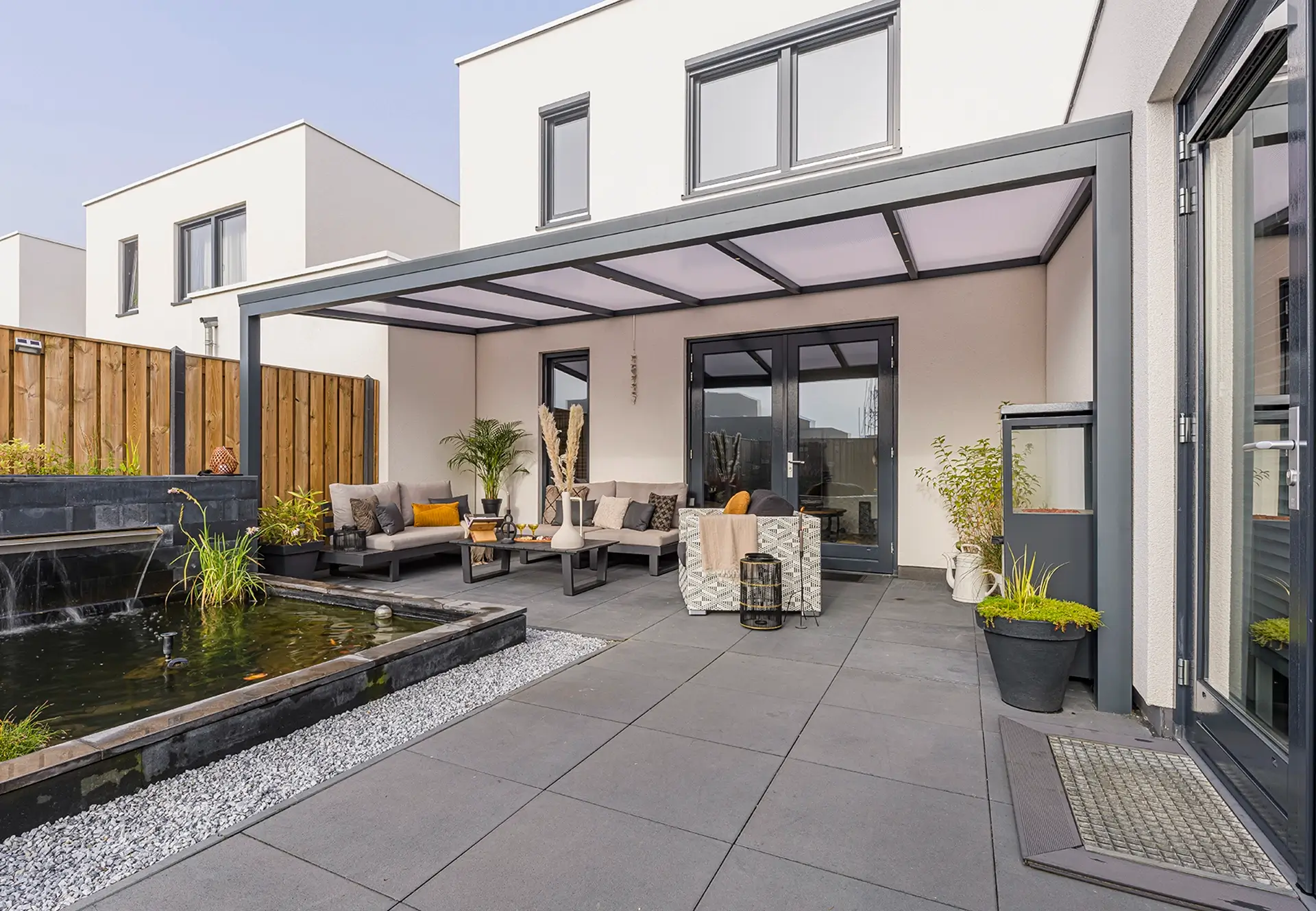 Verasol veranda in Helmond met polycarbonaat dak en stijlvolle loungeset aan vijver